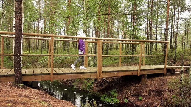 Two little beautiful girls walk on swamp, Estonia