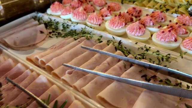 Gourmet deviled eggs with pink beet mousse and ham served on a luxury breakfast buffet platter, showcasing elegant catering appetizers for brunch, festive holiday events, and professional hospitality