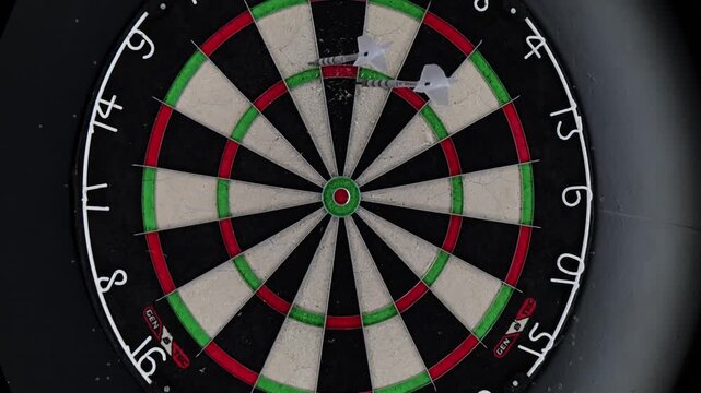 Darts arrows hit the target on a dartboard during the game