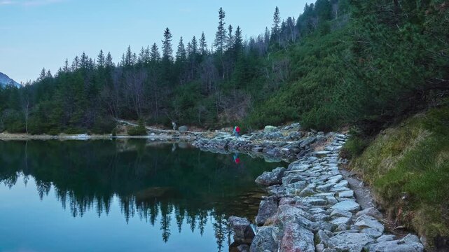 Two girls walking on the stone path around Lake Morskie Oko near Zakopane, Poland.