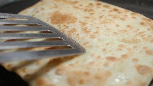 Making flatbread on a hot pan in a kitchen