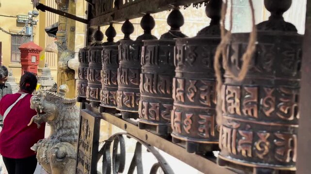 Close-up of Hands Spinning Traditional Bronze Prayer Wheels, Nepal