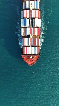 Vertical. Aerial view of container cargo ship in sea.
