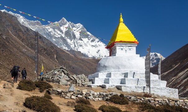 Stupa and prayer flags with mount Lhotse and two sherpas