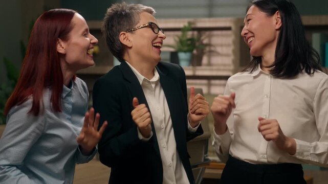 Office business team happy carefree three multiracial businesswomen dancing having fun different ages women multiethnic females dance together fooling celebrating work success partnership company joy