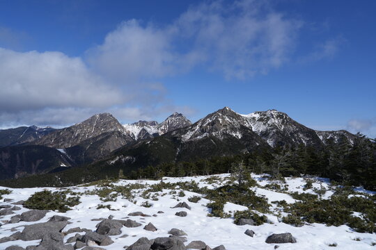 A quiet winter mountain landscape photographed in late February around Mount Amigasa and Nishidake in the southern Yatsugatake range, spanning Fujimi Town in Nagano Prefecture and Hokuto City in Yaman