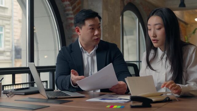 Two Korean business partners team stress paperwork aggressive CEO talking to woman businessman furious man arguing Asian Japanese Chinese intern businesswoman in office suffering difficulties conflict