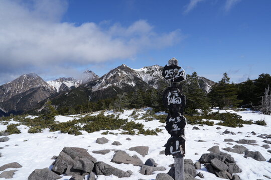 A quiet winter mountain landscape photographed in late February around Mount Amigasa and Nishidake in the southern Yatsugatake range, spanning Fujimi Town in Nagano Prefecture and Hokuto City in Yaman