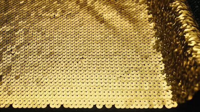 Sparkling gold and black reversible sequins fabric background texture