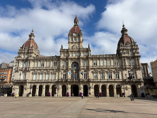 Obraz premium Historic city hall building with domes in European square under blue sky