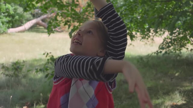 A beginner girl throws a basketball and makes the hoop. She follows the ball flight and reacts with bright happy joy.