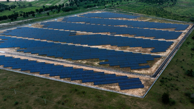 Aerial view of solar panels arranged in neat rows, a stark contrast to the surrounding dry, grassy landscape, Maiduguri, Borno, Nigeria.