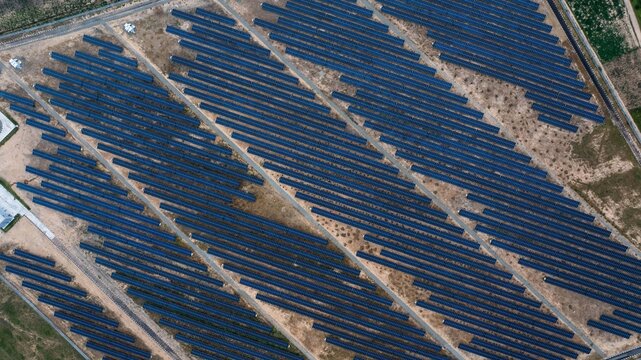 Aerial view of a vast array of dark blue solar panels stretches across the arid, light brown landscape, a testament to renewable energy, Maiduguri, Borno, Nigeria.