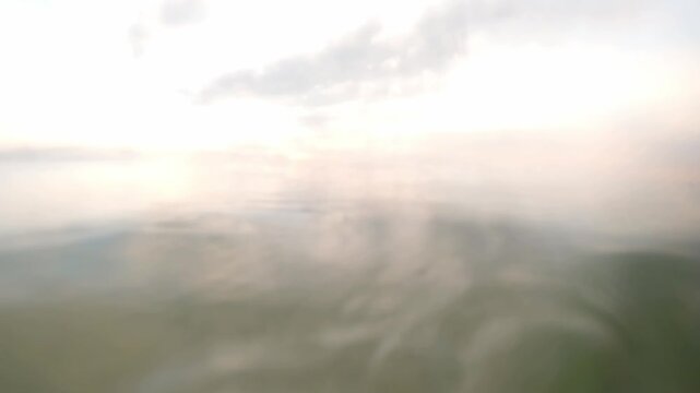 Over under split shot of calm lake water surface at sunset and underwater view of the lakebed. Lake Shkoder ecosystem, Albania.