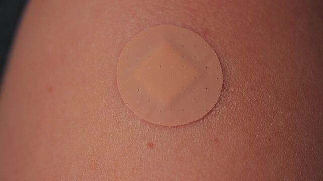 A close-up shot shows a small adhesive bandage placed on the shoulder after vaccination. The scene emphasizes healthcare, prevention, and personal responsibility. High quality 4k footage