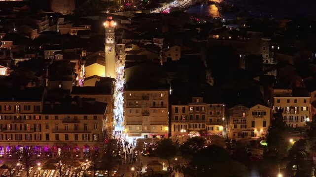 Stunning aerial night view of Corfu Old Town Greece, featuring illuminated Liston streets, bustling tourist crowds, and the iconic Saint Spyridon Church towers