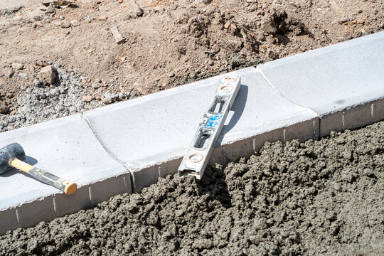 Spirit level and mallet on concrete curbstones The Concept of precision and accuracy