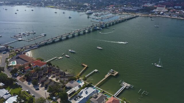Various boats travel under a bridge connecting St. Augustine's waterfront. Ideal for maritime or travel-related content.
