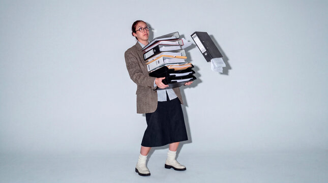 Determined office employee carrying overloaded document stack