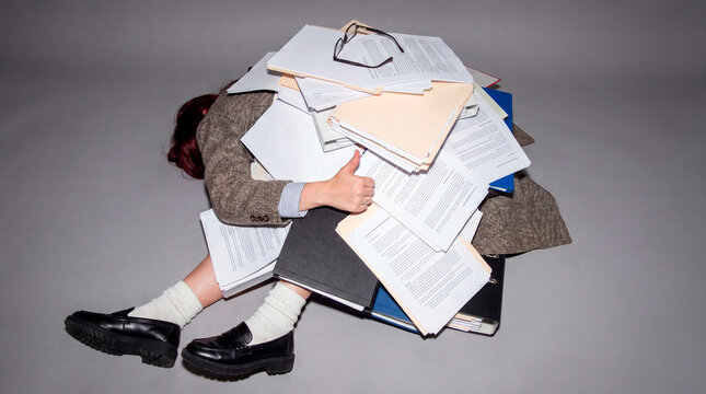 Resilient professional overwhelmed by massive paperwork pile showing workplace burnout concept
