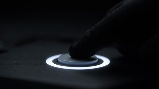 A finger presses a circular white-lit button in a dark setting, causing it to activate and glow with a vibrant blue light.
