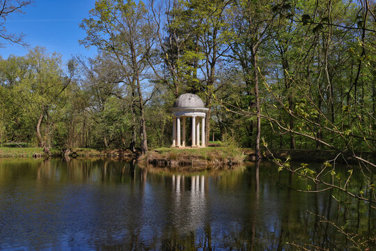 Klassizistischer Dianatempel mit Spiegelung im stillen Teich des Schlossparks L&uuml;tzschena im Fr&uuml;hling, Leipzig, Sachsen, Deutschland