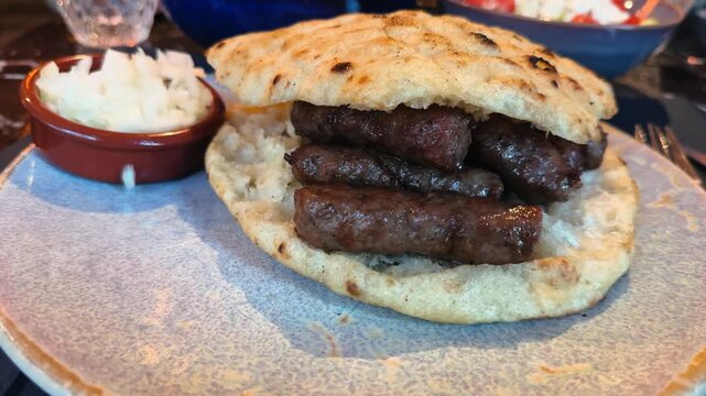 Sausage Cevapcici, traditional juicy Balkan sausages made from ground beef, grilled, and served with onions in pita bread. High quality 4k footage