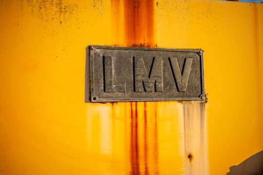 Gothenburg, Sweden - March 22 2026: LMV badge on weathered yellow industrial machine with rust stains.