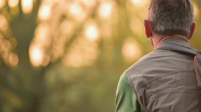 Cinematic close up slow motion shot of fisherman casting fishing rod in river during sunset. Warm golden light, outdoor angling action and peaceful freshwater nature scene. High quality FullHD footage