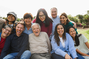 Group of multigenerational people smiling in front of camera - Multiracial friends with different ages having fun together - Main focus on caucasian senior face © DisobeyArt