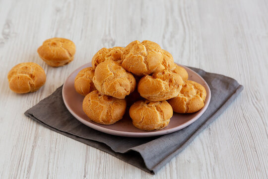 Homemade Mini Cream Puffs with Whipped Cream Filling on a Plate, side view.