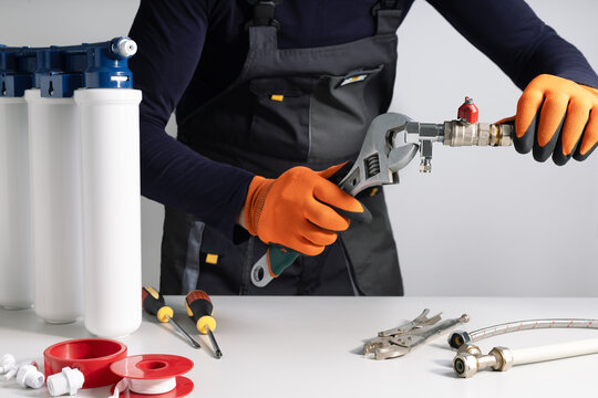 Plumber installing or repairing system of water filtration at home.