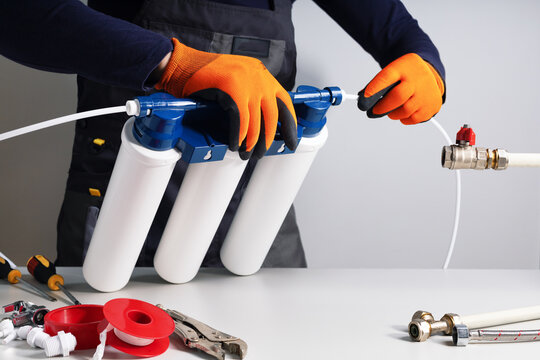  plumber or technician installing or repairing system of water filtration