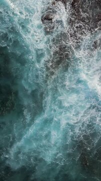 Aerial view of rocky, volcanic shoreline and foamy ocean waves flooding the seaside coast, Tenerife, Canary Islands, Spain.