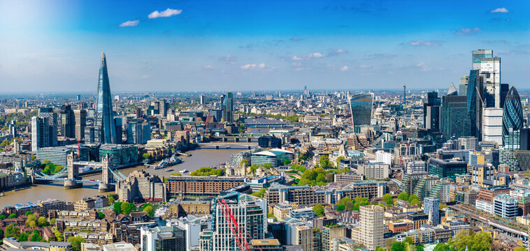 Panoramic aerial view of the skyline of London, England, spanning from London Bridge to the City skyscrapers during a sunny spring day