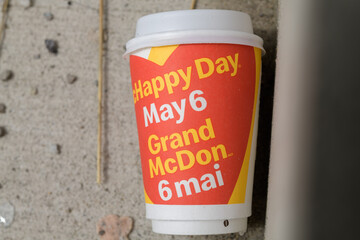 Naklejka premium discarded cup with on product advertising for McHappy Day, a yearly fundraising campaign run by McDonald’s in Canada (Grand McDon 6 mai), Toronto