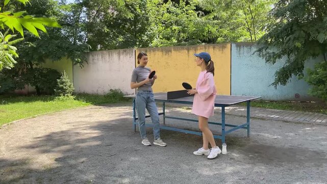 Outdoor sport - two Women Engage In Lively Table Tennis Game