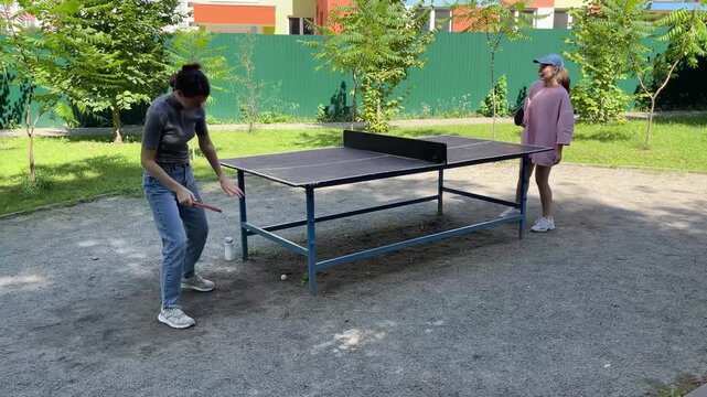 Outdoor sport - two Women Engage In Lively Table Tennis Game