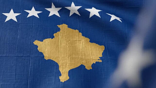 National flag of Kosovo with gold map and white stars waving in the wind