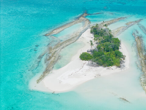 Aerial view of a secluded island paradise where turquoise waters meet the pristine white sand beach and lush greenery, Thuraakunu, Thiladhunmathee Uthuruburi, Maldives.