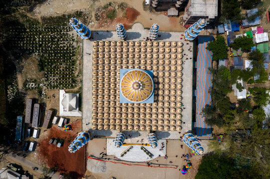 Aerial view of the vibrant Baitul Aman Jame Masjid's intricate dome and minarets contrast sharply with the surrounding structures, Tangail, Dhaka Division, Bangladesh.