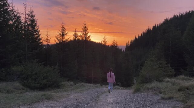 Woman travel in mountain forest at beautiful golden sunset