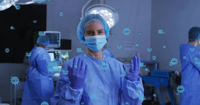 Preparing surgeon wearing blue gown raising hands in OR with purple gloves HUD sale icons