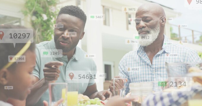 Pointing man in green polo speaking with checked-shirt senior and child on patio, grapes, overlays