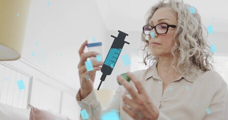 Fototapeta premium Inspecting senior wearing light blouse, glasses holding pill bottle, cap at home with syringe icon