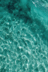 Fototapeta premium An aerial view captures , turquoise water. The sunlight creates bright, shimmering patterns on the water's surface