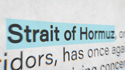 Close up macro shot of news headline mentioning Strait of Hormuz and oil prices with radial blur, conveying urgency in global trade, energy crisis and geopolitical tensions affecting shipping routes. © DBFilms