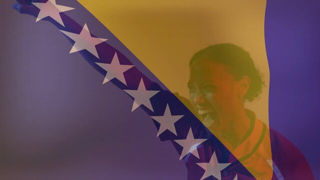 Mid-adult woman raising fist as flag opacity drops, celebrating sports win and pointing ball