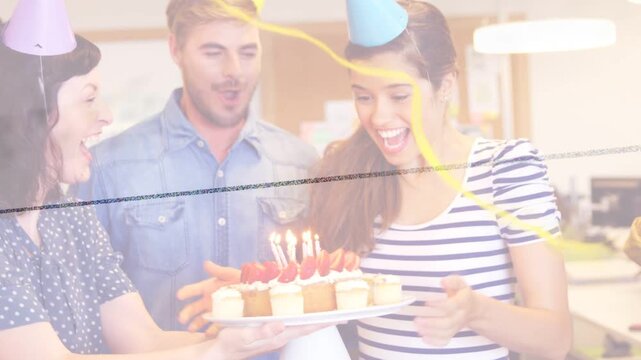 Woman reacting as coworkers bringing cake, office team celebrating birthday, blowing candles