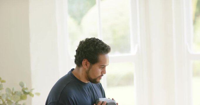 Midadult African American man adjusting grip at home, holding hex dumbbell at chest bracing for set